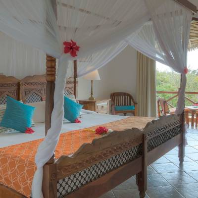 a bedroom with a bed and a chair in a room