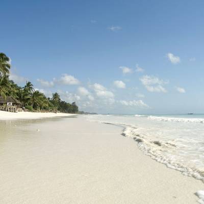 a sandy beach next to a body of water
