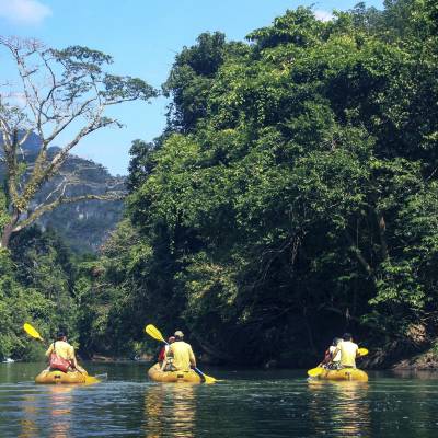 a yellow boat floating on top of a lake surrounded by trees