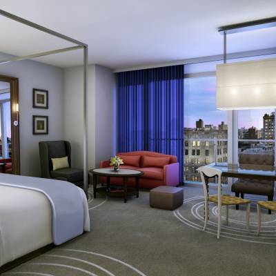 a bedroom with a bed and desk in a hotel room