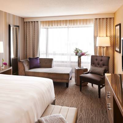 a bedroom with a bed and desk in a hotel room