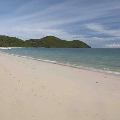 a sandy beach next to a body of water
