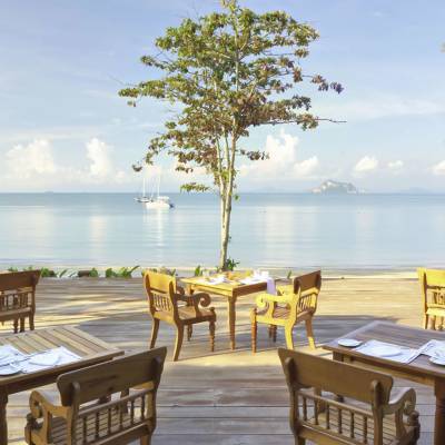 a row of wooden benches sitting next to a body of water