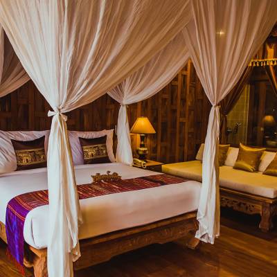 a bedroom with a bed and a chair in a room