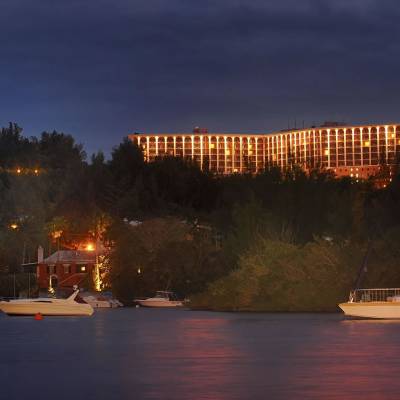 a boat on a body of water with a city in the night sky