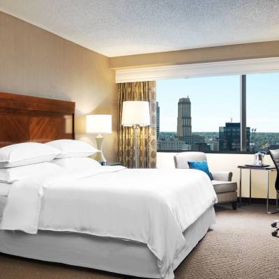 a bedroom with a bed and desk in a hotel room