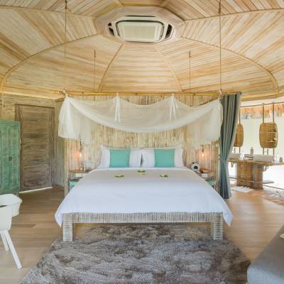 a bedroom with a bed and a chair in a room