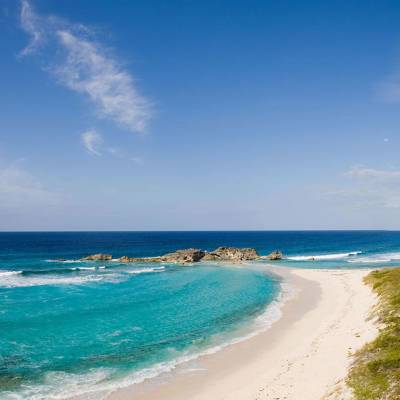 a sandy beach next to a body of water