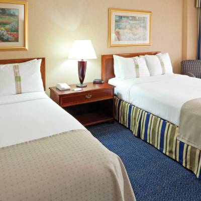 a bedroom with a bed and desk in a hotel room