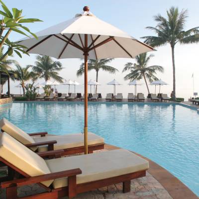 a group of lawn chairs sitting next to a pool of water