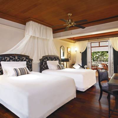 a bedroom with a bed and a chair in a room