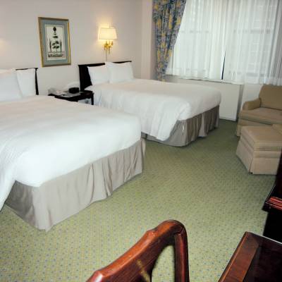 a bedroom with a bed and desk in a hotel room