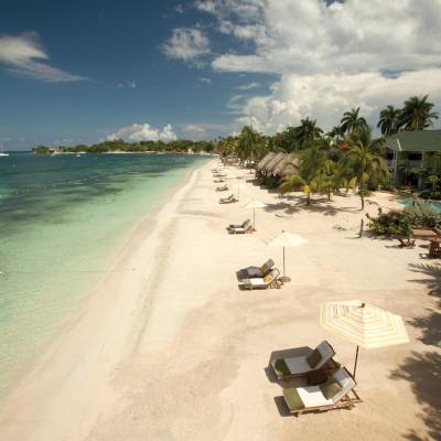 a sandy beach next to a body of water