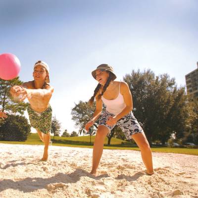 a group of people playing frisbee on the beach