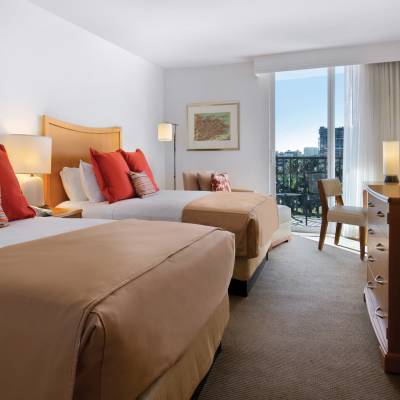 a bedroom with a bed and desk in a hotel room