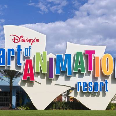 a close up of a sign with Disney's Art of Animation Resort in the background