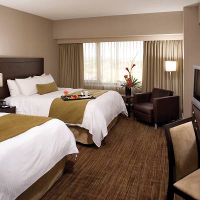 a bedroom with a bed and desk in a hotel room