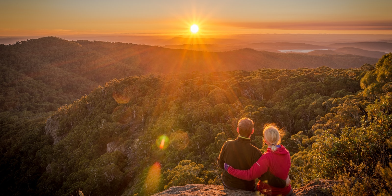 Enchanting Travels A young couple enjoying the beautiful sunrise on Mount Kaputar in New South Wales Australia Minimizing Carbon Emissions