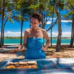 Junge Frau bei einem Barbecue am Strand von Australien