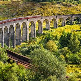 Enchanting Travels UK & Ireland Tours Glenfinnan Railway Viaduct in Scotland with the Jacobite steam train passing over