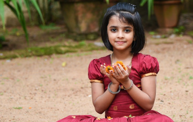 Girl holding flower in hand during Onam Festival Kerala Tour