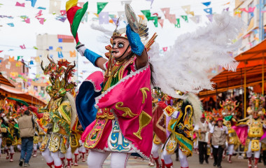 Enchanting Travels Bolivia Tours Oruro, Bolivia, carnival dancers wearing traditional masks and dresses on the street during the carnival