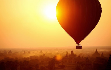 Heißluftballon schwebt bei Sonnenaufgang über den Tempeln und Pagoden von Bagan, Myanmar