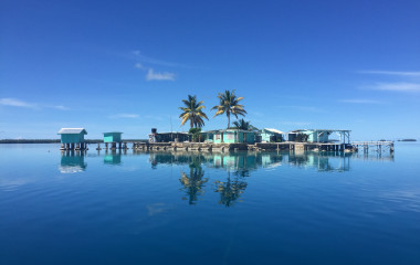 Hütten und Palmen im Wasser des Manihiki-Atolls der Cook-Inseln