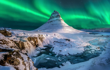 northern lights appear over Mount Kirkjufell in Iceland.
