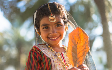 Beautiful-Omani-girl-in-traditional-dress-is-playing-in-the-park-in-Oman
