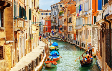Enchanting Travels Rio Marin Canal with boats and gondolas from the Ponte de la Bergami in Venice, Italy.