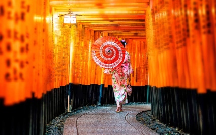 Japanese girl in Yukata with red umbrella at Fushimi Inari Shrine in Kyoto, Japan - best time to visit Japan