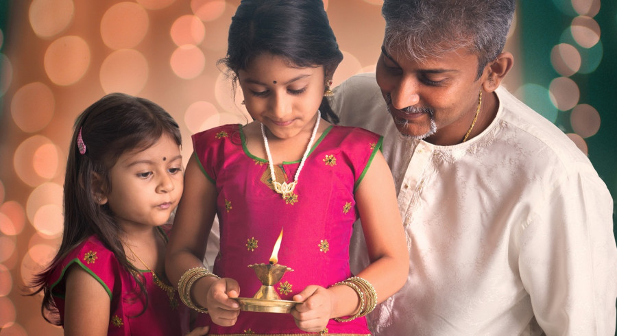  Mädchen, das eine Lampe auf ihrer Hand hält, die Diwali feiert