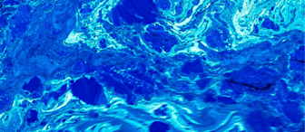 Abstract image resembling a marbled or fluid pattern in varying shades of blue and turquoise. The composition features swirling and overlapping textures, creating a sense of depth and motion. Some areas have a lighter, almost white appearance, adding contrast.