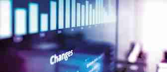 A digital screen displaying a bar chart with vertical bars of varying heights. The chart is labeled "Changes," and the background is blurred with a purple tint. This is likely used for data analysis or presentation purposes.