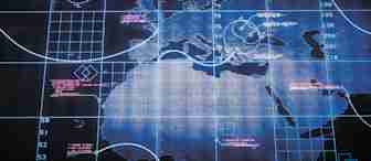 A high-tech digital map featuring geographical outlines of Europe, Africa, and parts of Asia. Overlaid are various data points, grids, and circular radar-like graphics, with some text in white and pink indicating information or coordinates. The overall color scheme is blue.