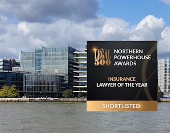 A large office building with a modern glass facade sits behind a river under a partly cloudy sky. An award graphic in the foreground reads: "The Legal 500 Northern Powerhouse Awards - Insurance Lawyer of the Year - Shortlisted.