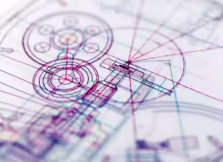 A close-up of a technical drawing or blueprint featuring intricate and overlapping lines, circles, and geometrical shapes in various colors like red, blue, and purple. The design appears complex, with mechanical and architectural elements intersecting.