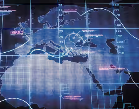 A high-tech digital map featuring geographical outlines of Europe, Africa, and parts of Asia. Overlaid are various data points, grids, and circular radar-like graphics, with some text in white and pink indicating information or coordinates. The overall color scheme is blue.