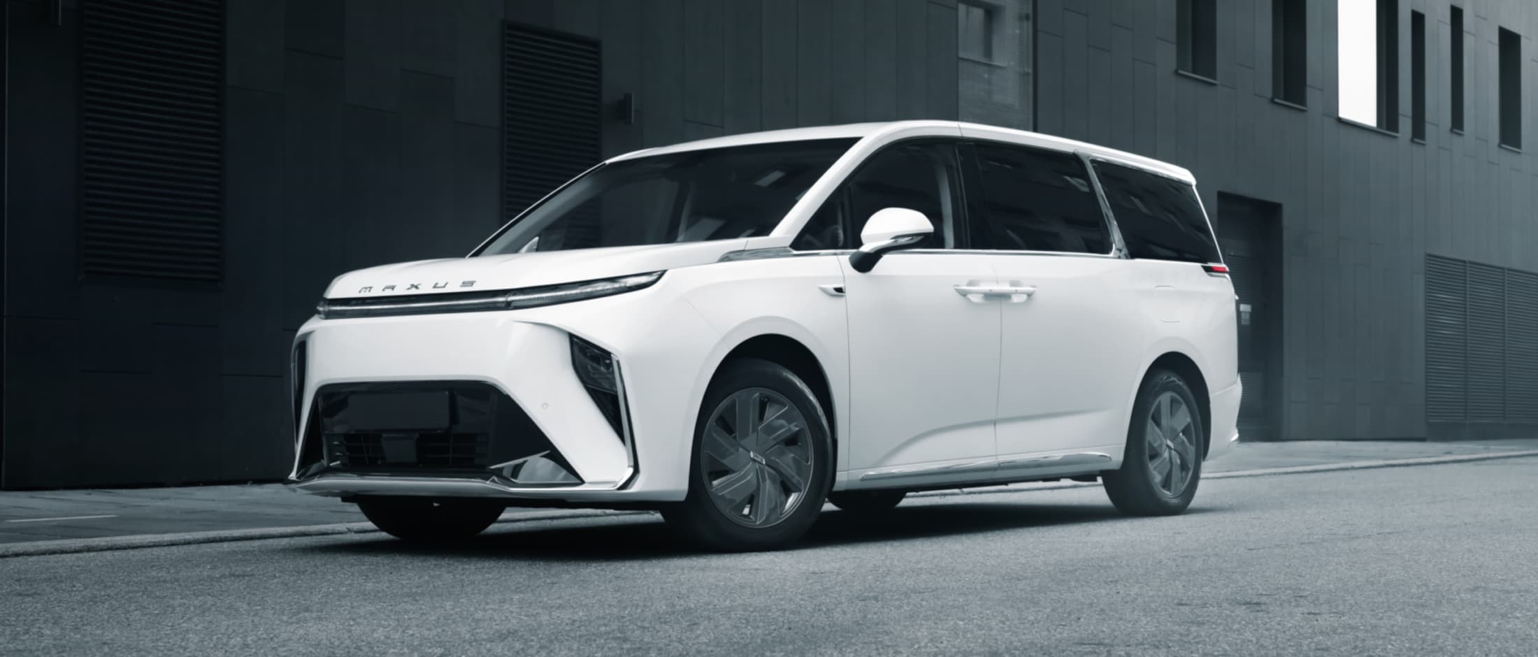 Maxus Mifa fra Frydenbø Bilsenter parkert med kontorbygg i bakgrunnen.
