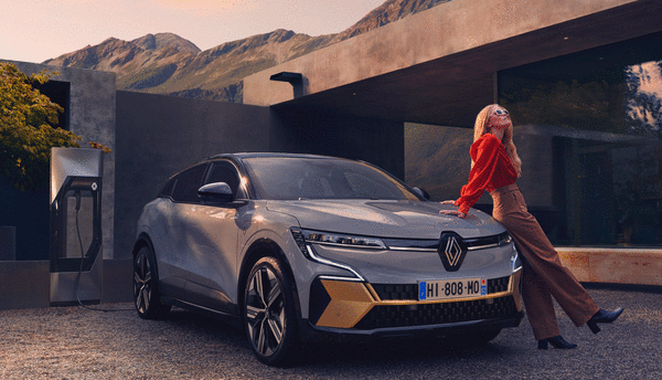 Renault-Megane-e-tech---kvinne-på-panser-foran-hus