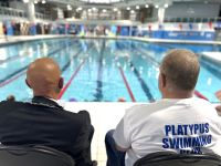 Photo of the mayor and the club chairman watching gala participants in a swimming pool