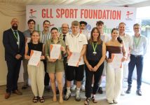 A group of athletes pose with their award certificates
