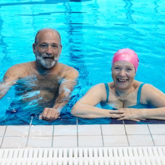 An image of a pair of senior members in-between swimming lengths of the pool.