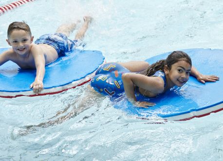 two children on floats in a pool