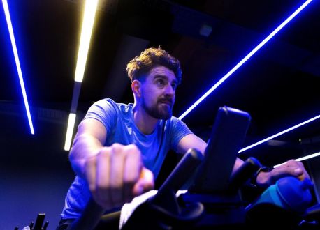 Man on exercise bike with blue lights