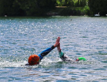 Two swimmers high fiving in the lake