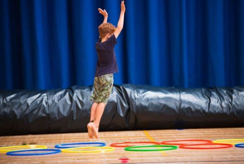 image shows a boy jumping through hoops