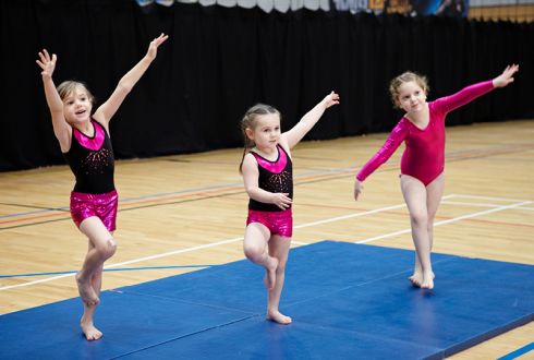 image shows three girls in a gymnastics pose