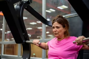 A woman working out at the gym using a exercise machine